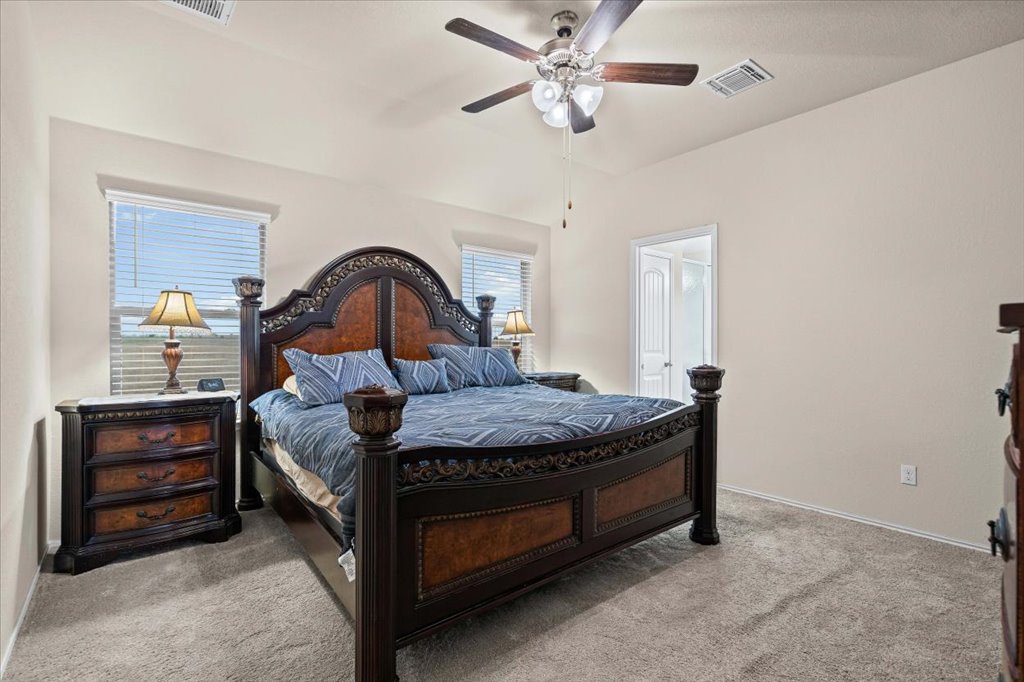 212 Plata Lane Jarrell, TX 76537 - Photo 16 of 30 Bedroom with a ceiling fan and light colored carpet