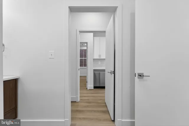 a view of a hallway with wooden floor and closet