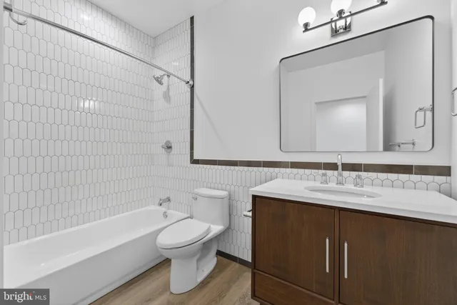 a bathroom with a toilet sink a mirror a bathtub and shower