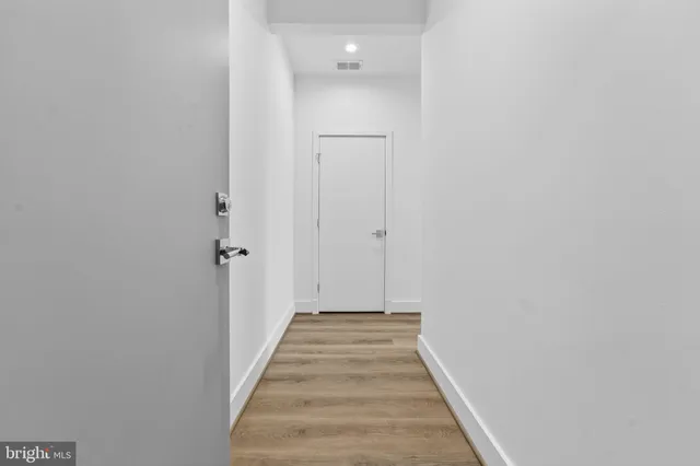 a view of a hallway with wooden floor