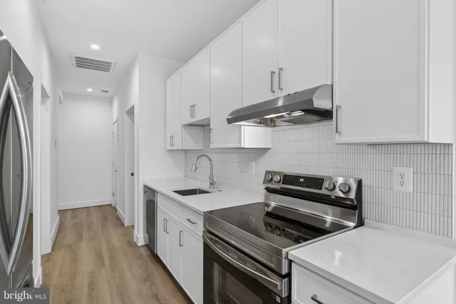 a kitchen with stainless steel appliances a stove a sink and a refrigerator