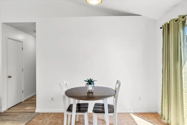 a dining room with furniture and a potted plant