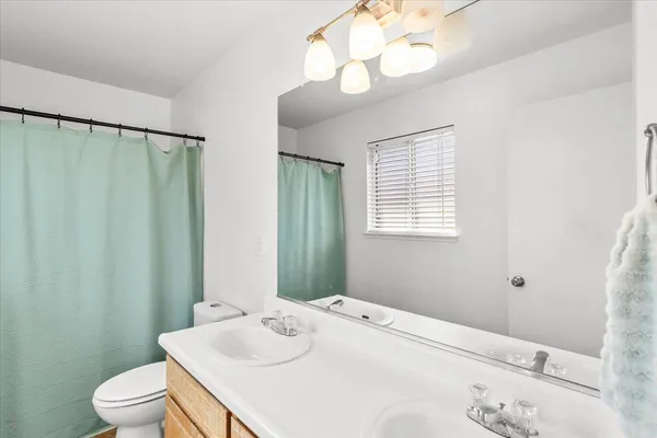 a bathroom with a sink vanity granite and toilet
