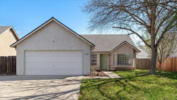 a view of house with a yard and garage