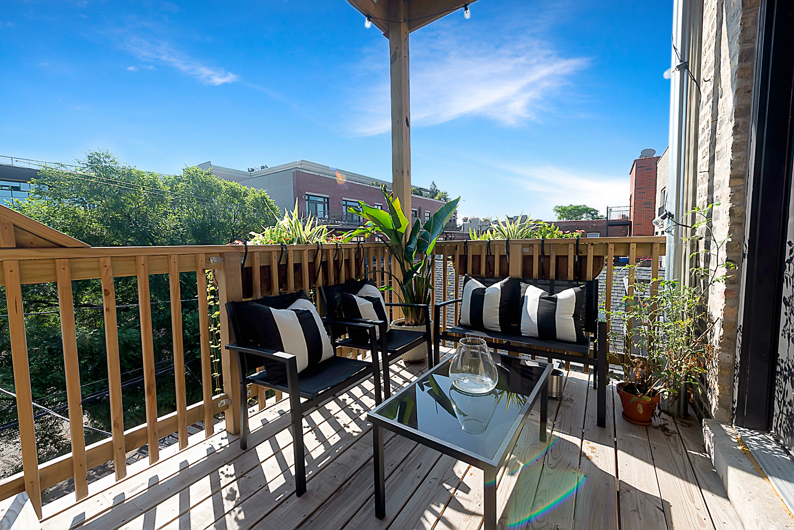 3517 North Reta Avenue, Unit 3R Chicago, IL 60657 - Photo 2 of 9 a view of balcony with chairs potted plants with wooden floor and fence