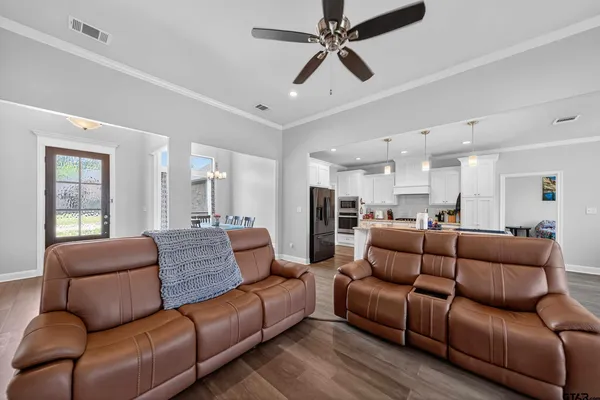 a living room with furniture white walls and a ceiling fan