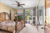 Undisclosed Address Tehachapi, CA 93561 - Photo 25 of 39 a bedroom with a bed and a large window with a chandelier fan
