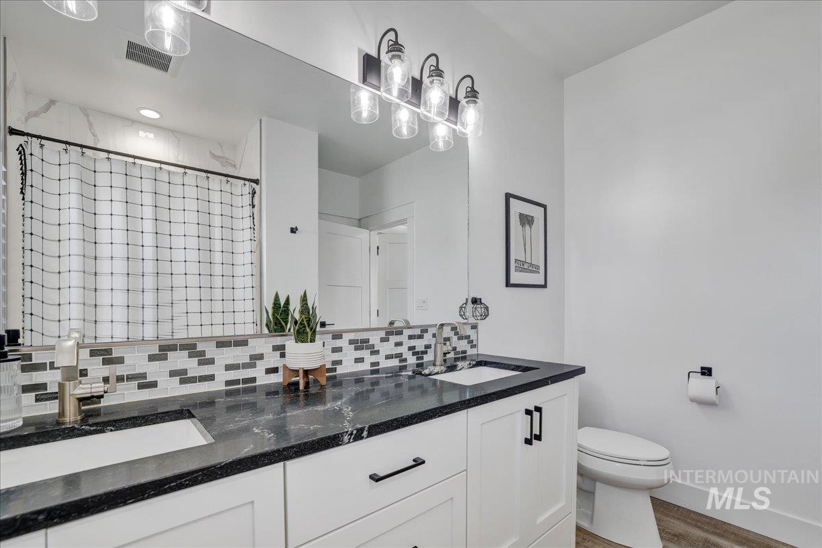 2078 Red Rock Way Twin Falls, ID 83301 - Photo 20 of 49 Full bathroom with double vanity, decorative backsplash, and wood finished floors