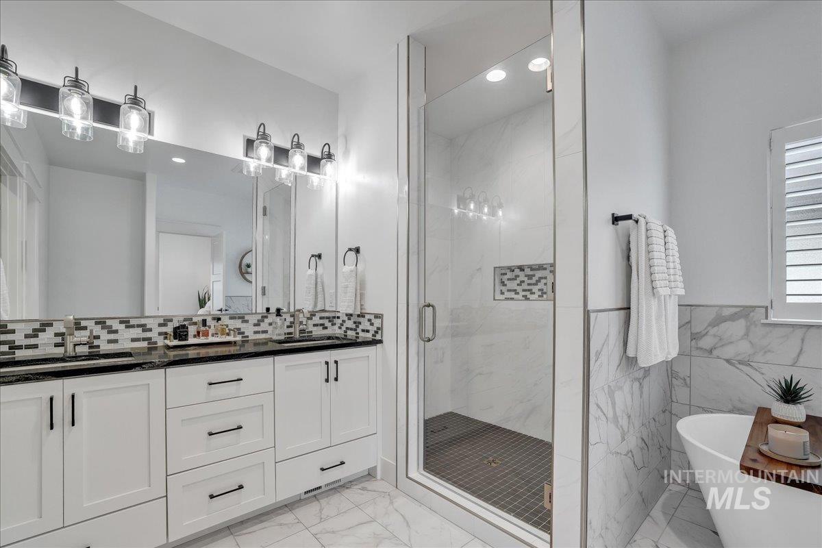 2078 Red Rock Way Twin Falls, ID 83301 - Photo 29 of 49 Full bathroom with marble finish flooring, a shower stall, double vanity, a soaking tub, and tile walls