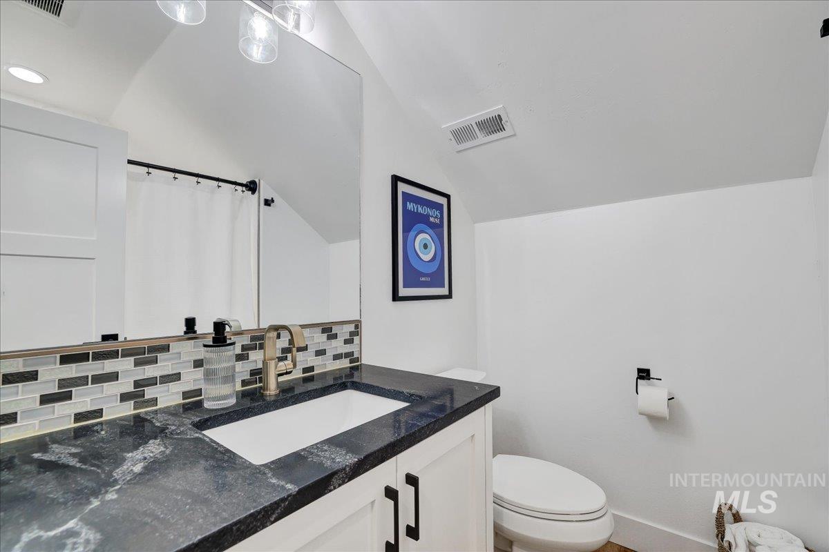 2078 Red Rock Way Twin Falls, ID 83301 - Photo 32 of 49 Bathroom featuring decorative backsplash, vaulted ceiling, vanity, and curtained shower