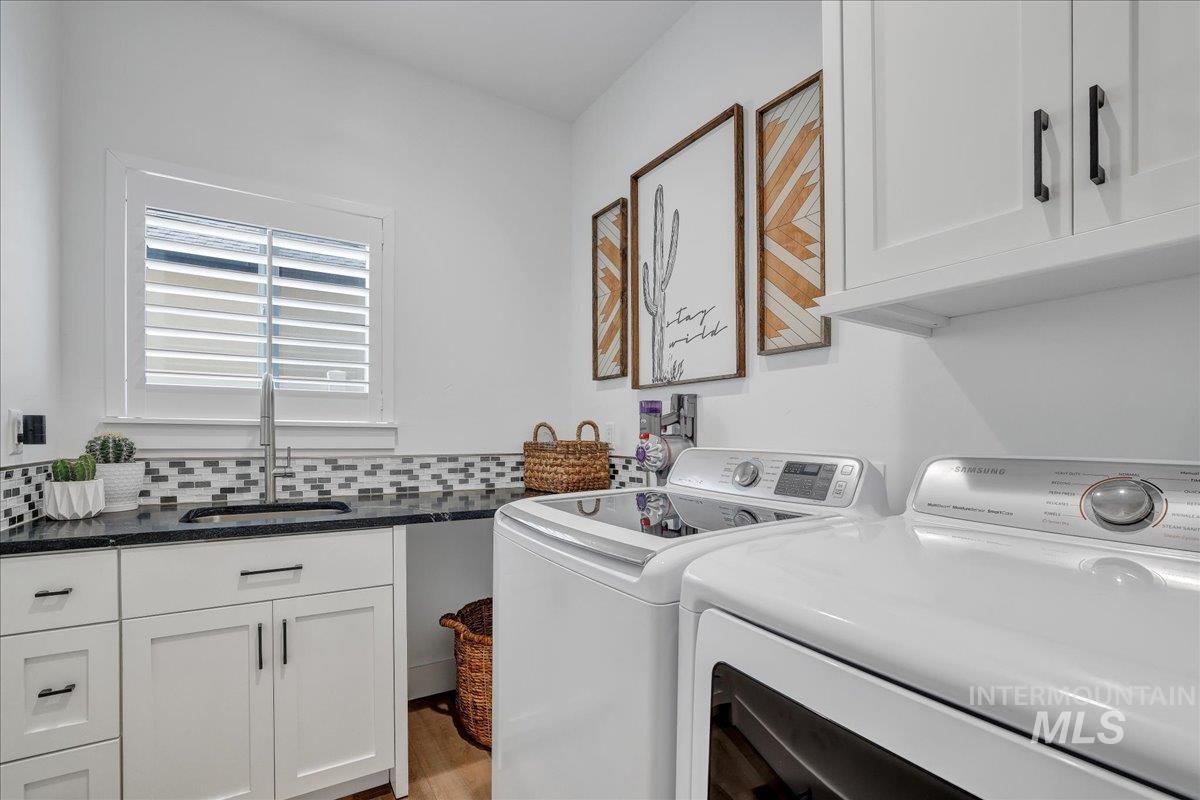 2078 Red Rock Way Twin Falls, ID 83301 - Photo 41 of 49 Laundry area with washing machine and clothes dryer, cabinet space, and wood finished floors
