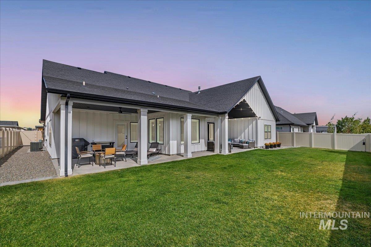 2078 Red Rock Way Twin Falls, ID 83301 - Photo 45 of 49 Back of house at dusk with an outdoor living space, board and batten siding, and a fenced backyard