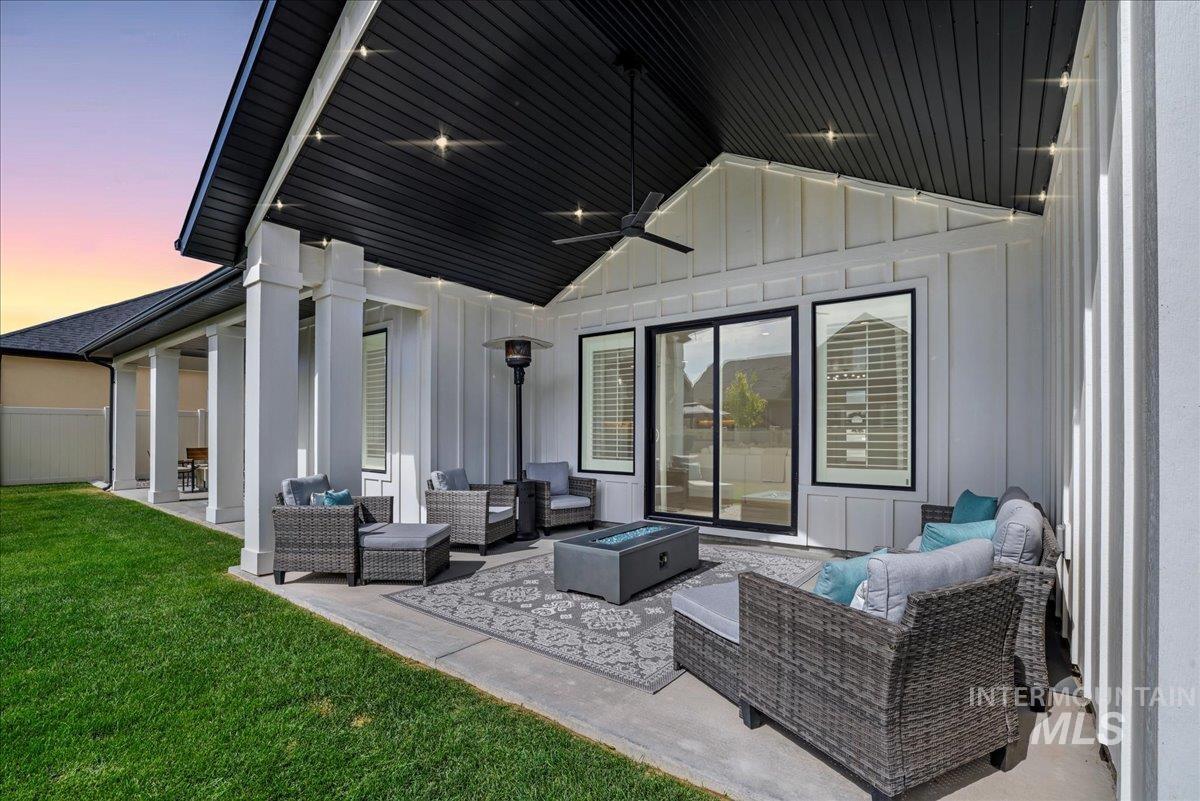 2078 Red Rock Way Twin Falls, ID 83301 - Photo 47 of 49 Patio terrace at dusk featuring an outdoor living space with a fire pit, a patio area, a ceiling fan, and a lawn