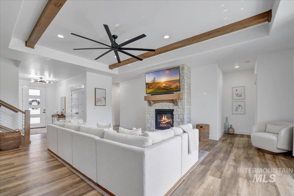 2078 Red Rock Way Twin Falls, ID 83301 - Photo 9 of 49 Living room featuring beam ceiling, light wood-type flooring, a fireplace, ceiling fan, and stairs