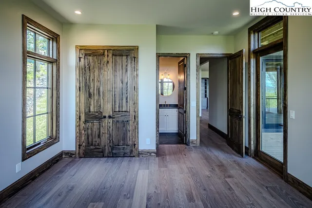 a view of a hallway with wooden floor and windows