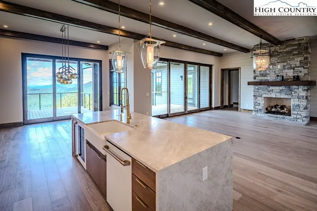 an open kitchen with granite countertop a stove and a wooden floors