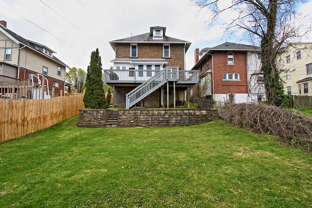 Large flat back yard for entertaining. Beautiful retaining wall with steps to upper level.
