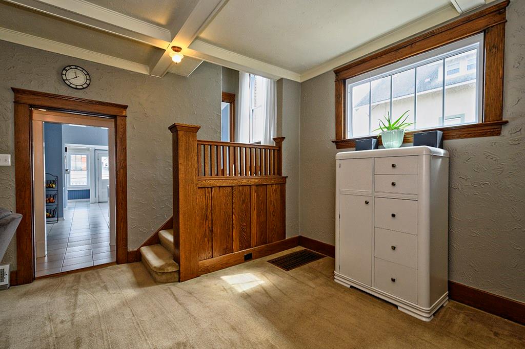 Over-sized entry boasts original wood work, coffer ceiling and tons of natural light.