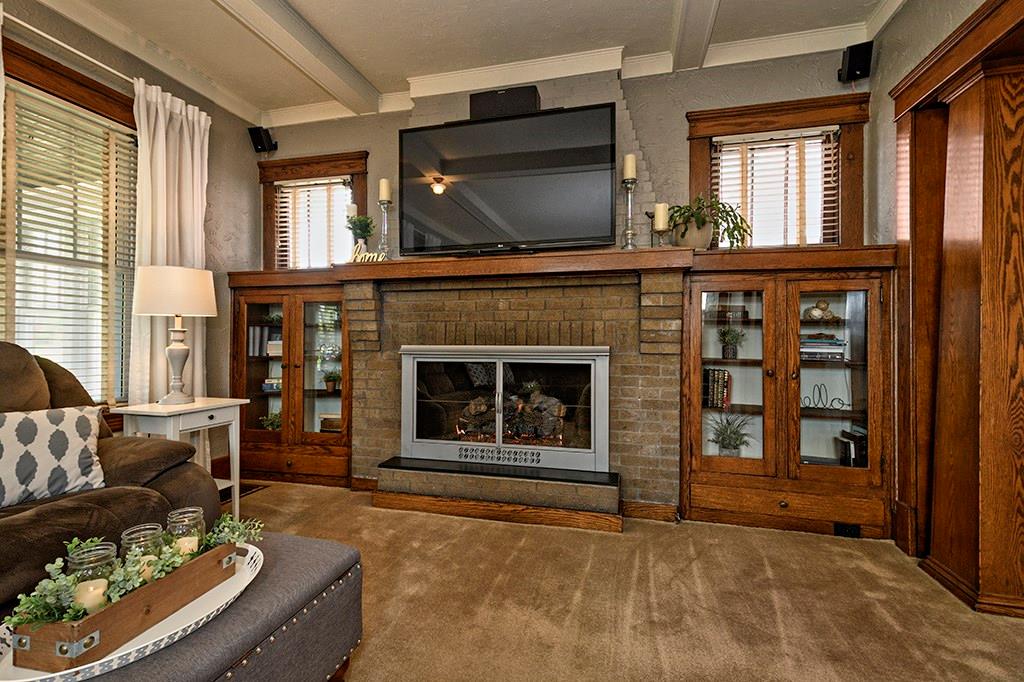 Original woodwork surrounds this brick gas fireplace. Sellers have run wiring for surround sound.