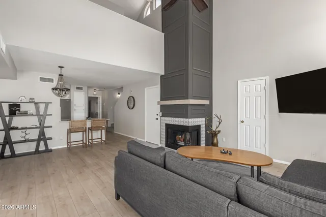 a living room with furniture a flat screen tv and a fireplace