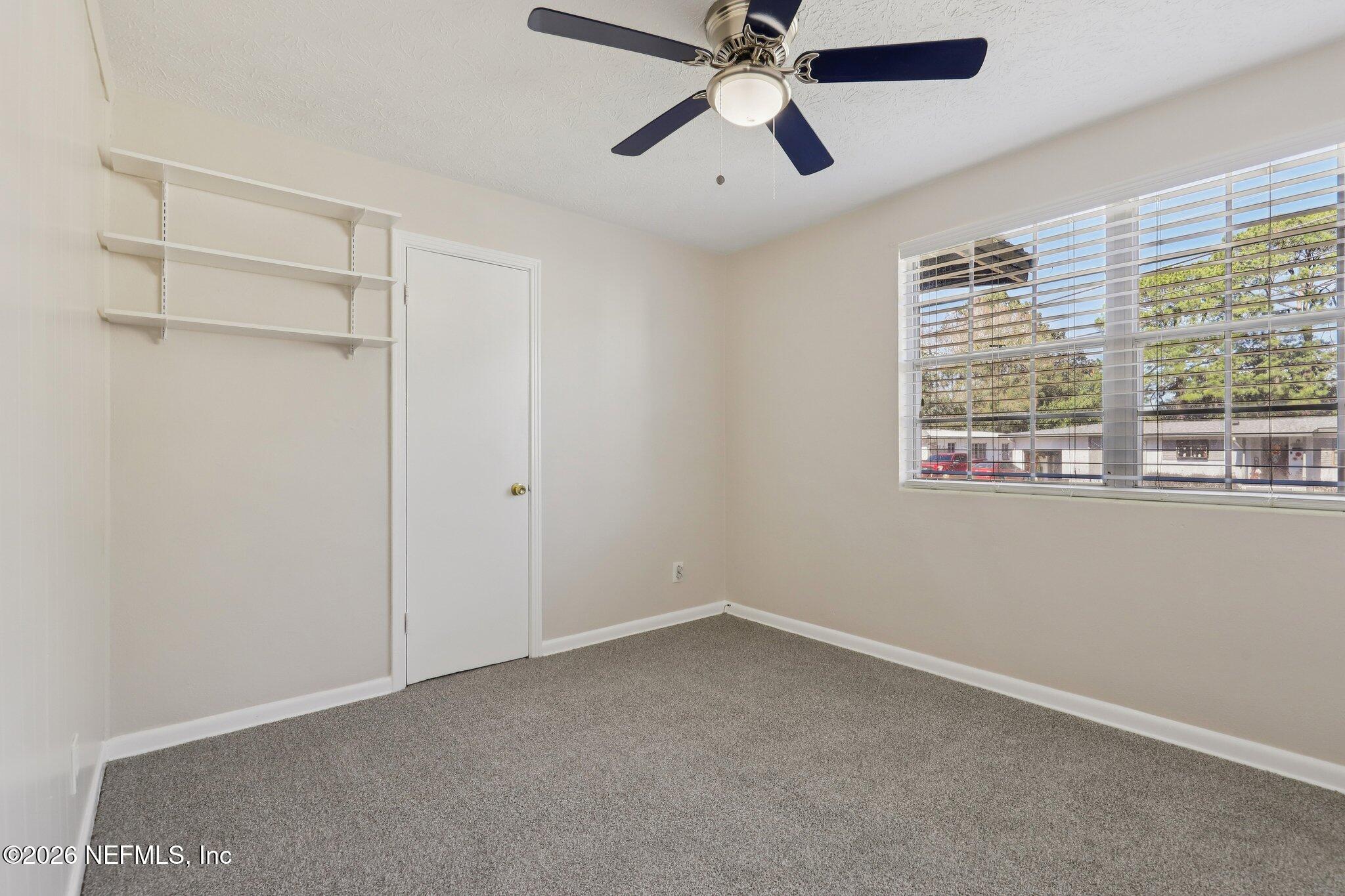 7004 Waikiki Road Jacksonville, FL 32216 - Photo 14 of 41 a view of an empty room with a window and a ceiling fan