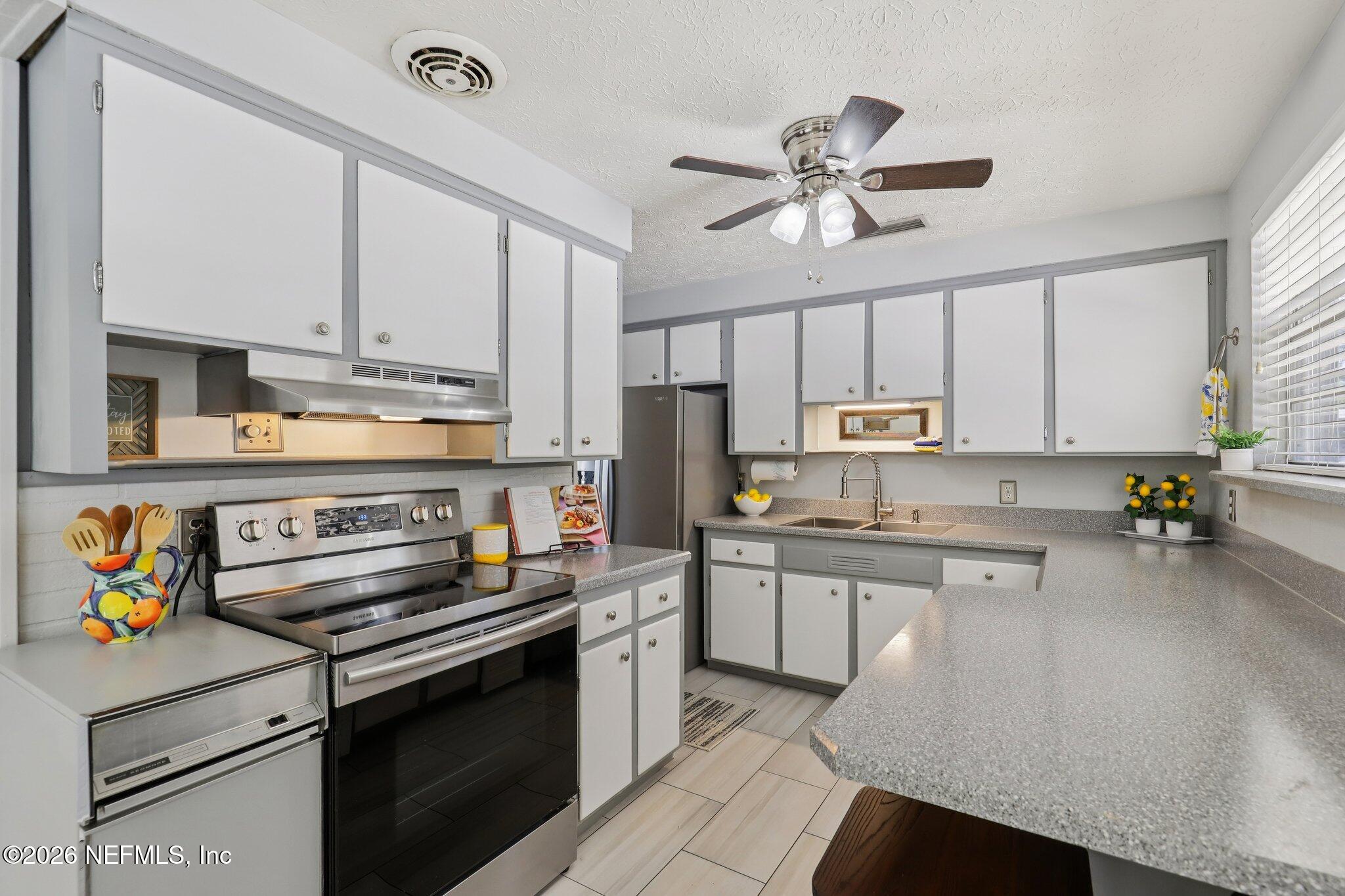 7004 Waikiki Road Jacksonville, FL 32216 - Photo 28 of 41 a kitchen with stainless steel appliances a stove a sink and cabinets