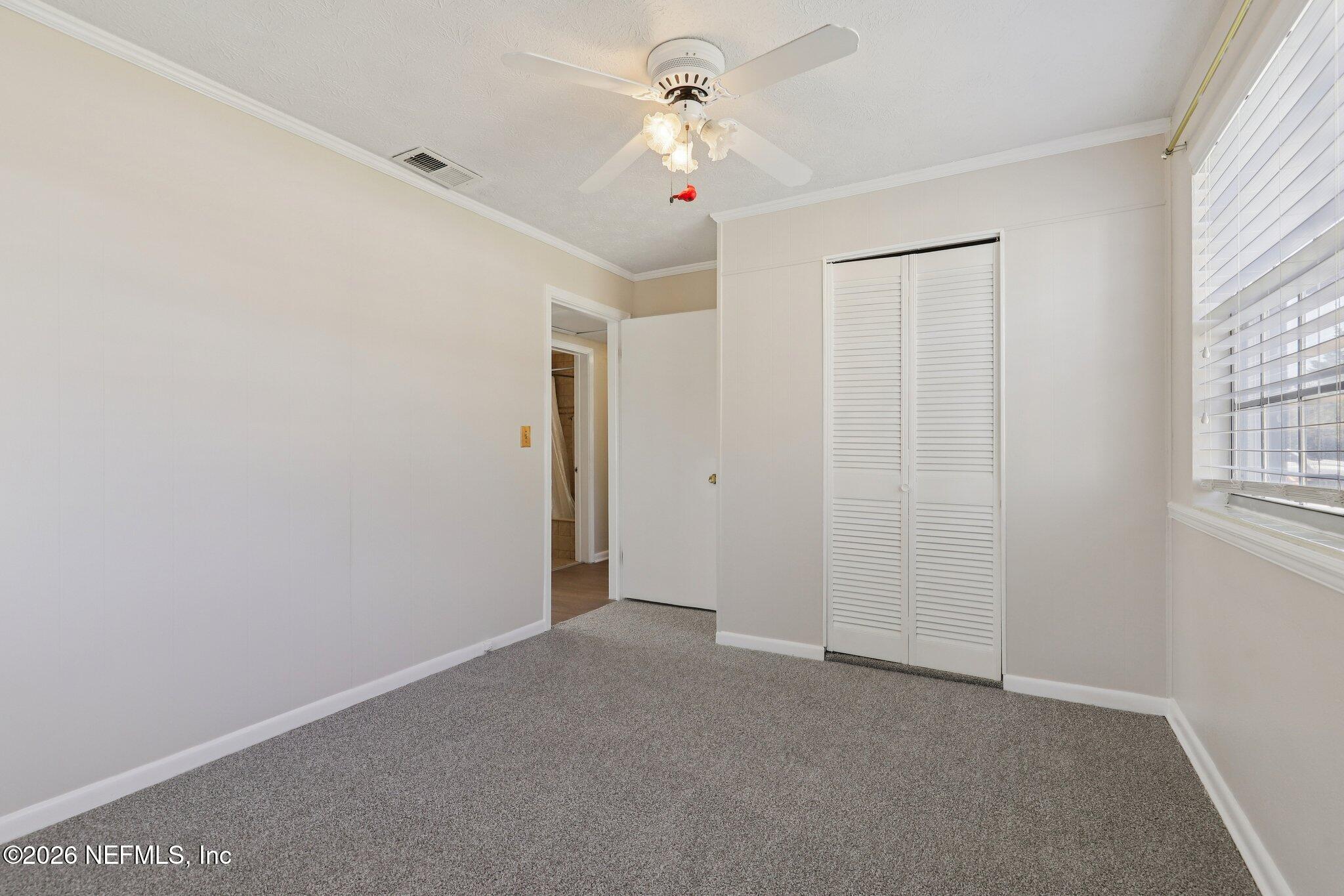 7004 Waikiki Road Jacksonville, FL 32216 - Photo 31 of 41 a view of a room with a ceiling fan and a window