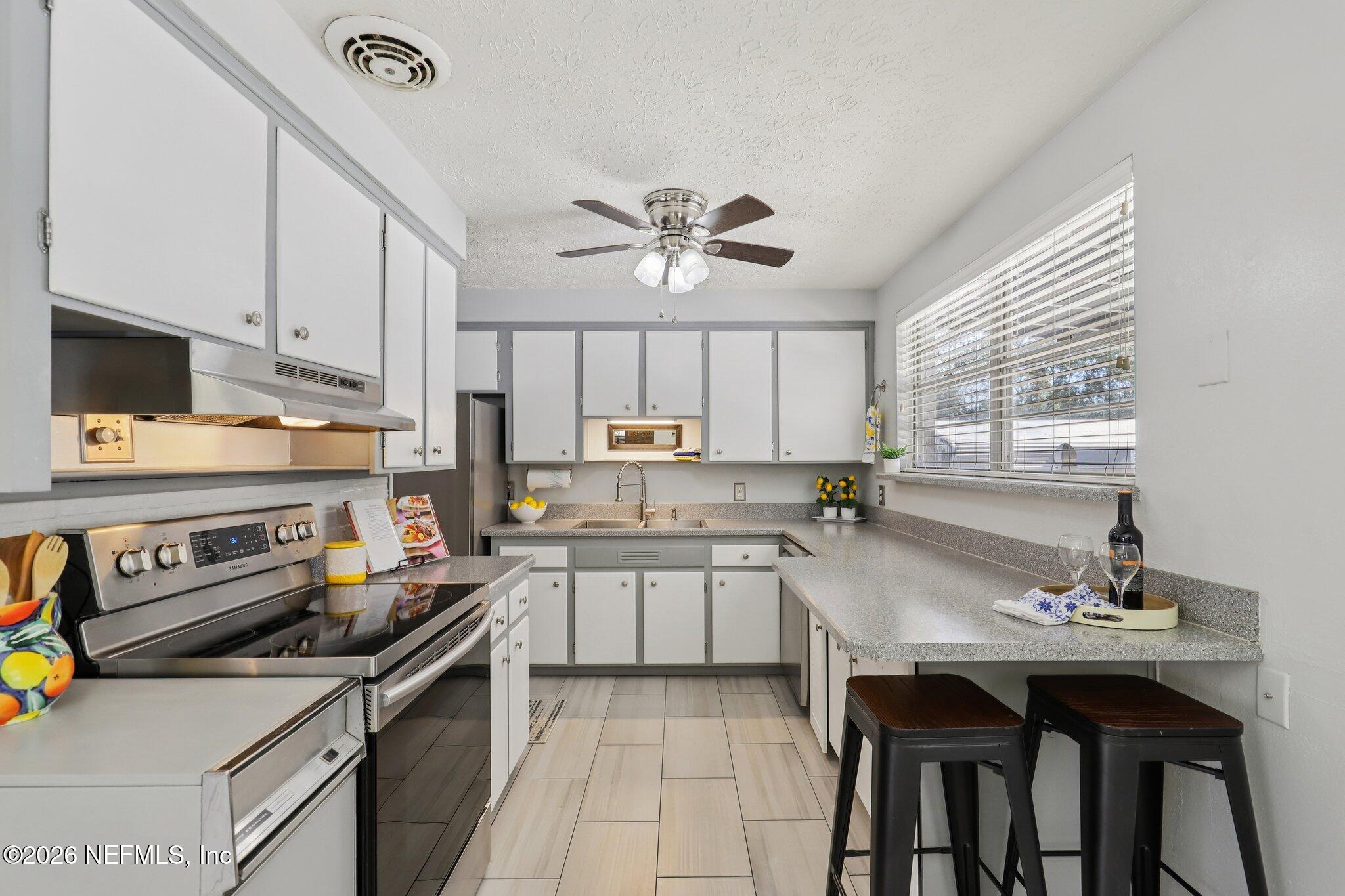 7004 Waikiki Road Jacksonville, FL 32216 - Photo 8 of 41 a kitchen with a stove a sink and a refrigerator