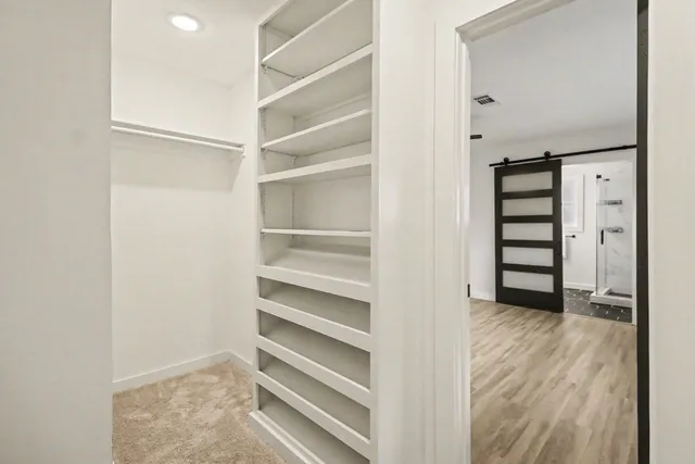 a view of walk in closet with empty racks
