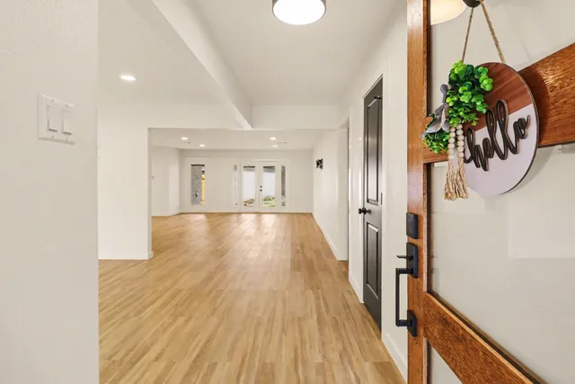 a view of a hallway with wooden floor and stairs