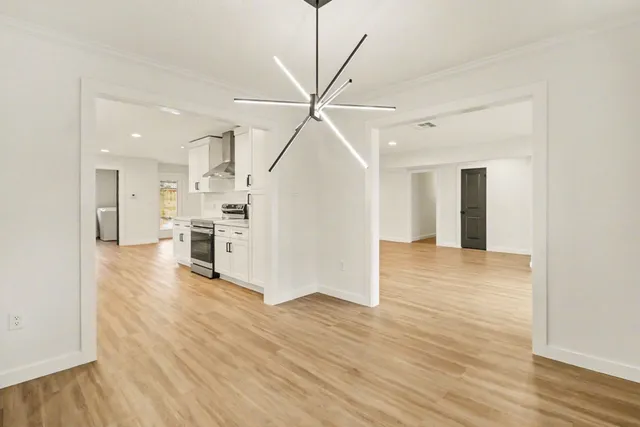 a view of a kitchen with wooden floor and a ceiling fan