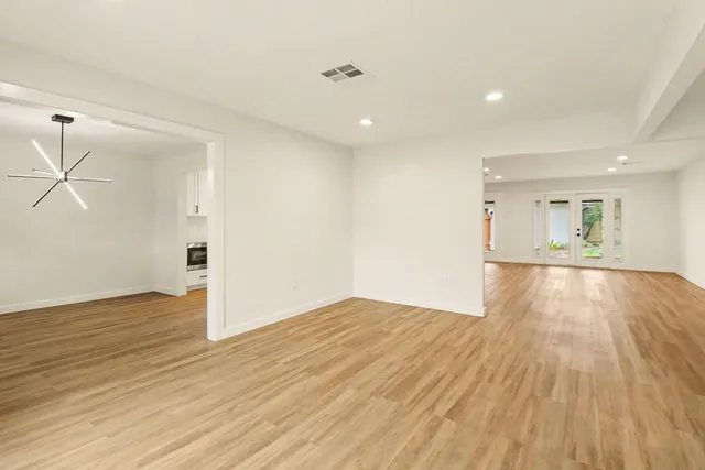 a view of empty room with wooden floor and windows