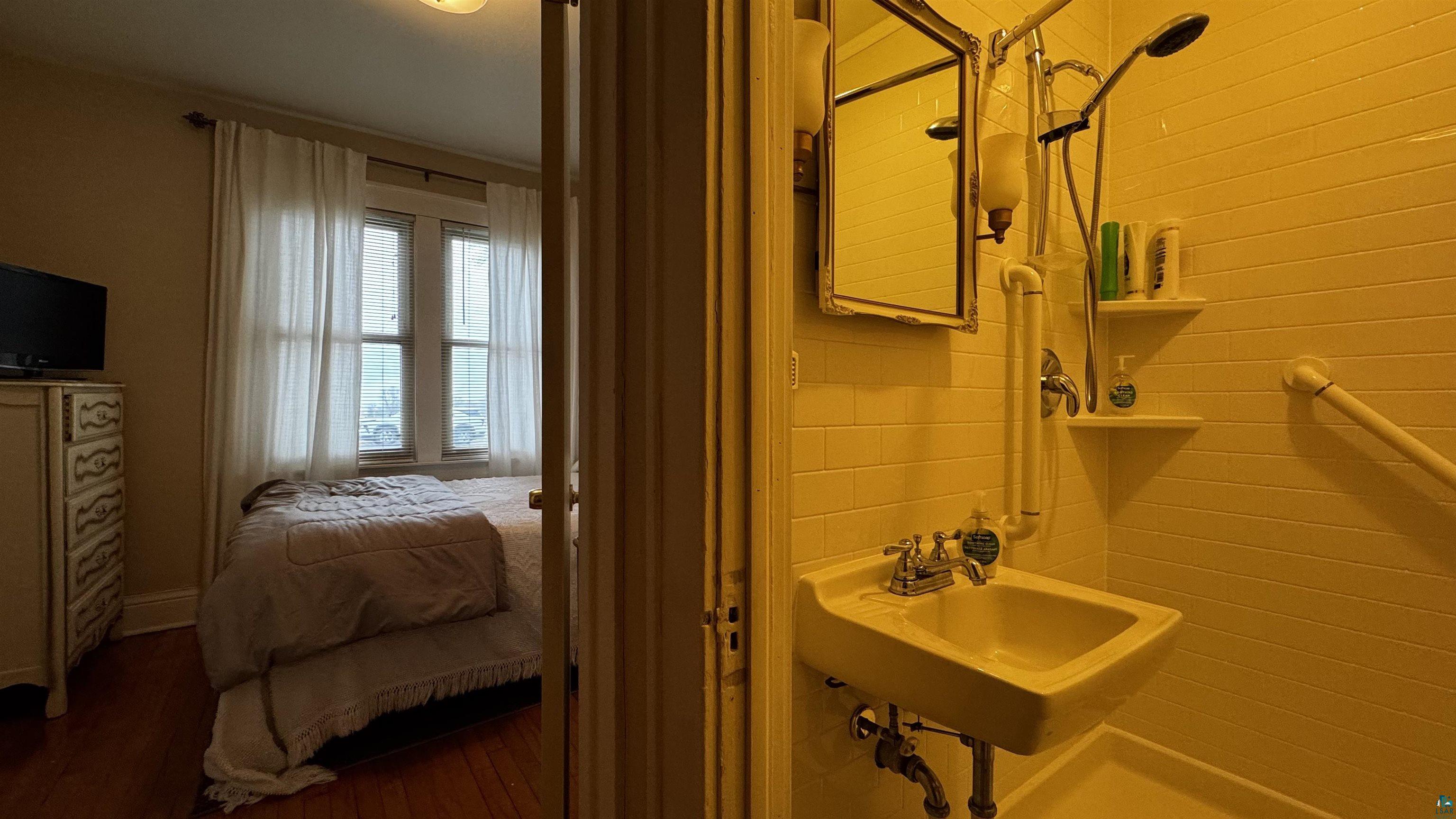 817 Harrison Street Eveleth, MN 55734 - Photo 13 of 29 Compact bathroom featuring a white porcelain sink, chrome fixtures, and white subway tile walls