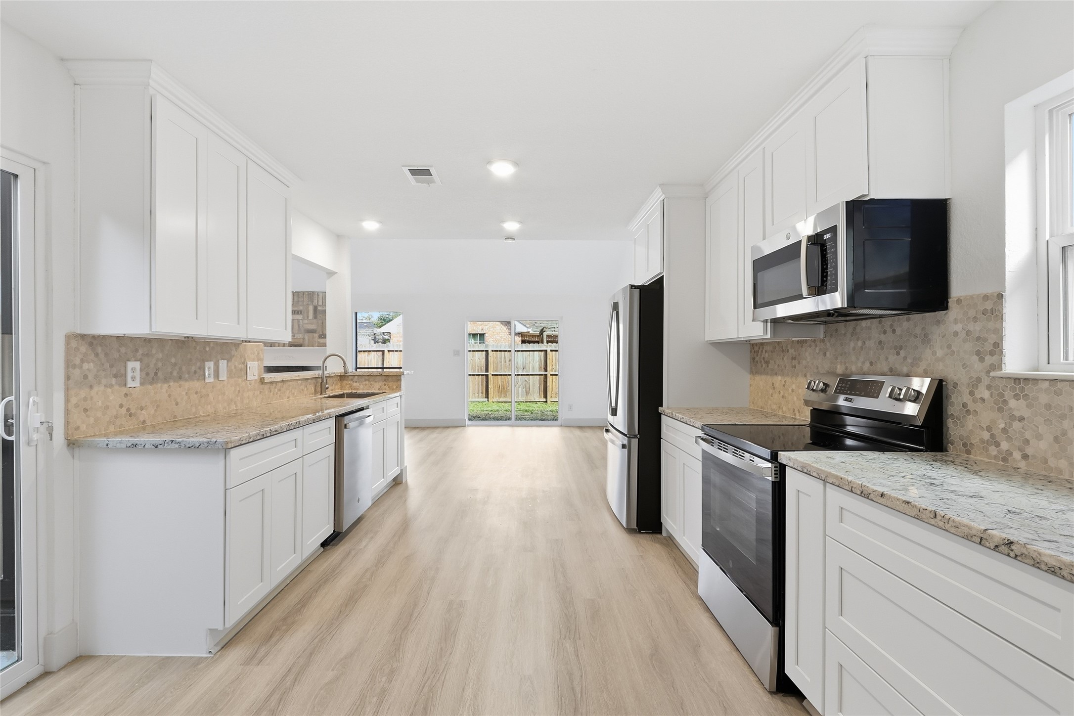 19110 Baton Pass Humble, TX 77346 - Photo 15 of 41 a large kitchen with stainless steel appliances granite countertop a lot of counter space a sink and dishwasher a stove top oven with wooden floor