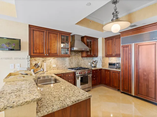 a kitchen with stainless steel appliances granite countertop a sink stove and refrigerator