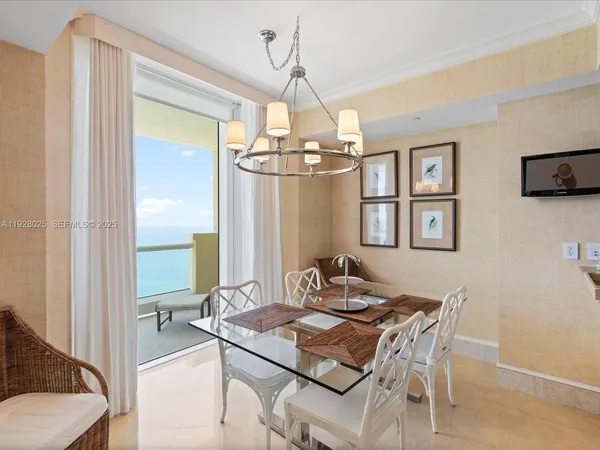 a dining room with wooden floor a chandelier a wooden table and chairs