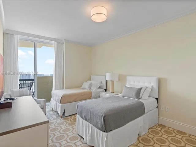 a bedroom with two beds and a large window