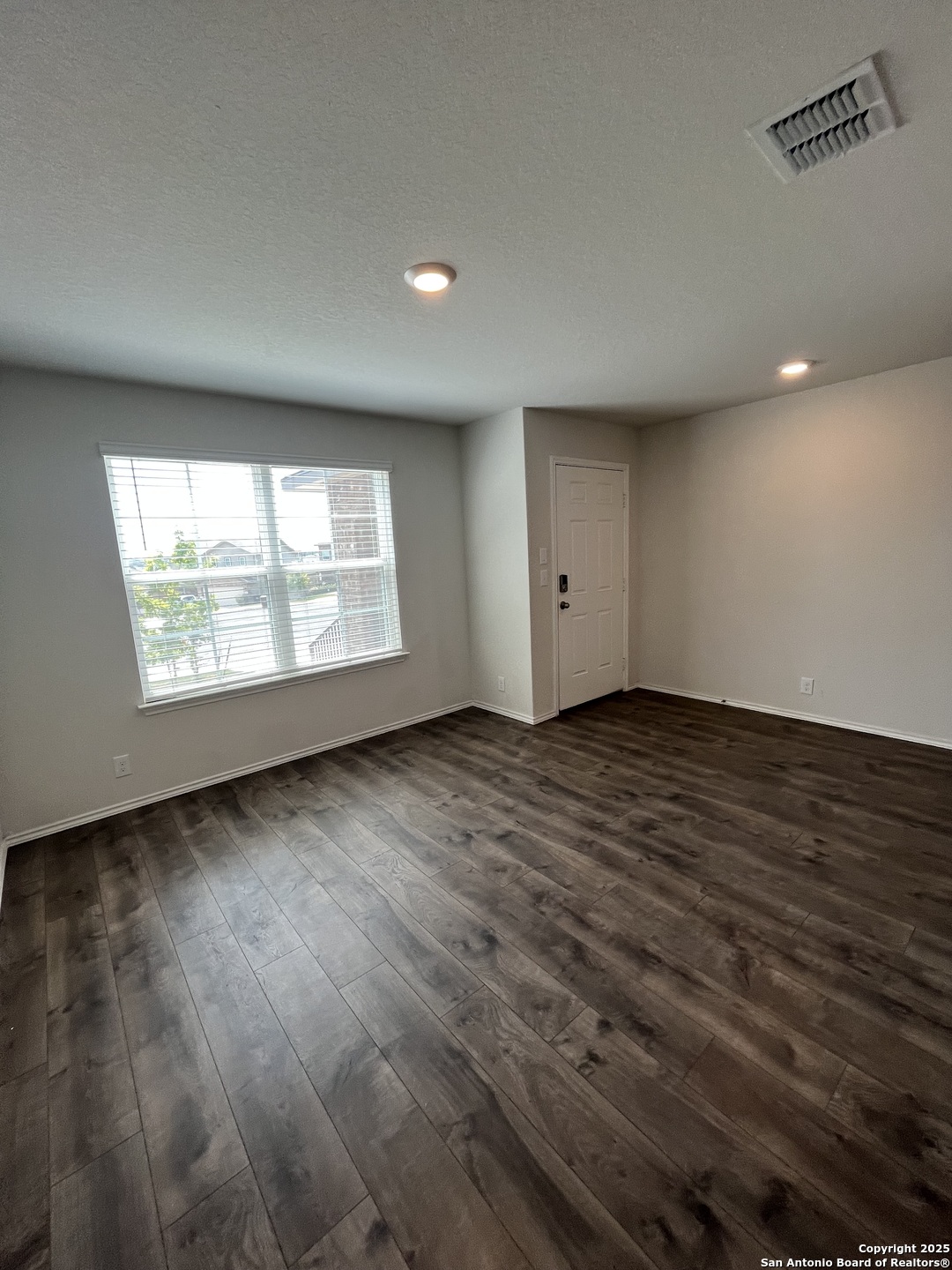 6218 Tadpole Bluff Converse, TX 78109 - Photo 11 of 23 an empty room with wooden floor and windows