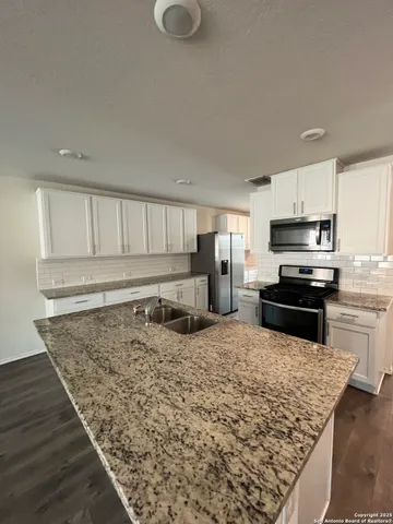 a kitchen with sink refrigerator and stove