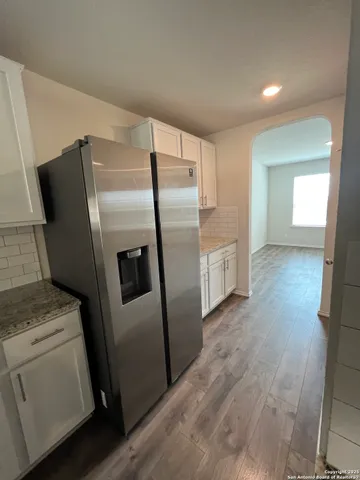a kitchen with white cabinets and stainless steel appliances