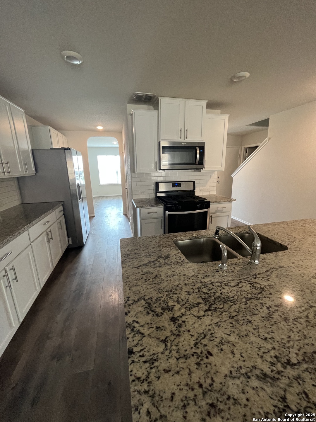 6218 Tadpole Bluff Converse, TX 78109 - Photo 5 of 23 a kitchen with stainless steel appliances a sink a stove top oven a chimney and a refrigerator