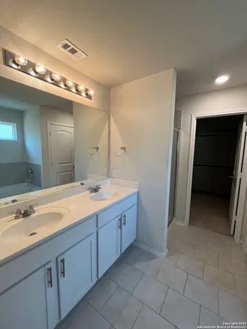 a spacious bathroom with a double vanity sink and a mirror
