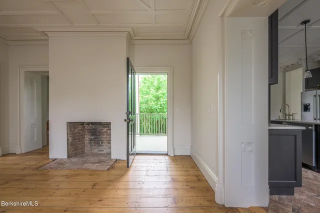 a view of an empty room with a fireplace and a window