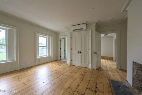 an empty room with window and wooden floor