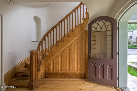 a view of entryway with wooden floor and a front door