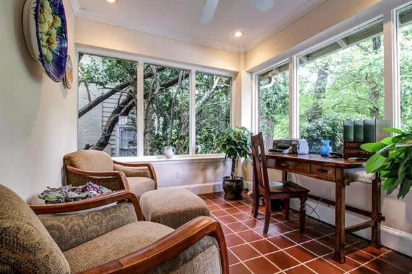 a living room with patio furniture and a potted plant
