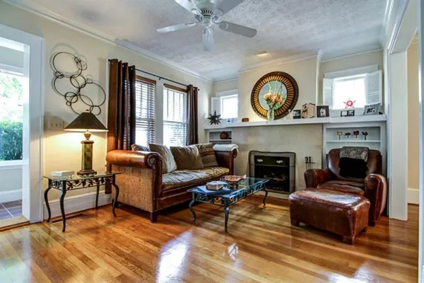a living room with furniture a fireplace and a large window