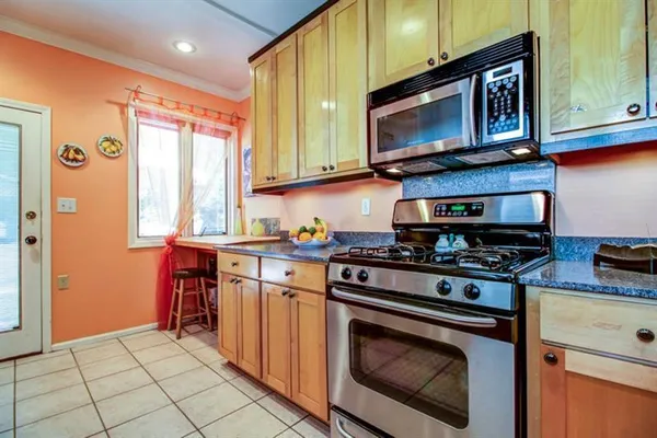 a kitchen with stainless steel appliances granite countertop a stove top oven microwave and cabinets