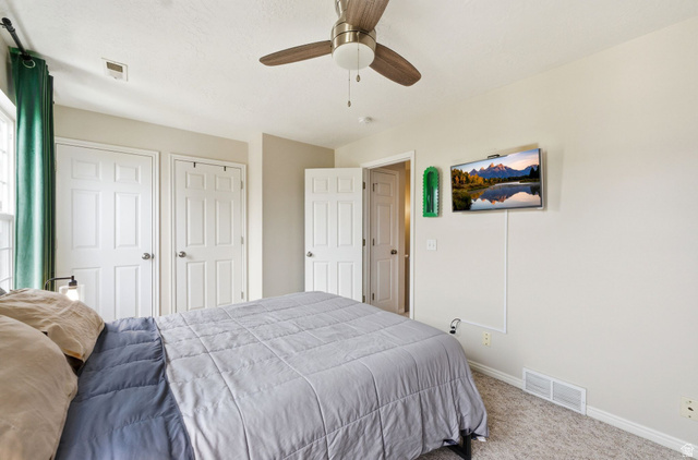 515 Inverness Lane, Unit 207 Heber City, UT 84032 - Photo 13 of 26 Carpeted bedroom with two closets and ceiling fan