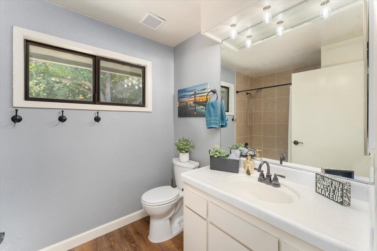 12325 Craig Avenue Red Bluff, CA 96080 - Photo 34 of 68 a bathroom with a toilet a sink a mirror and a window